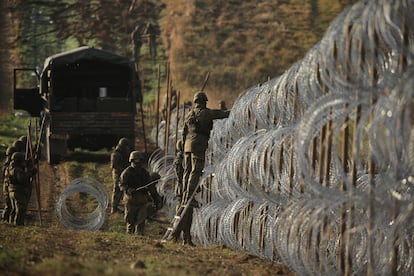 Soldados polacos instalan alambre de púas a lo largo de la frontera polaca con el enclave ruso de Kaliningrado, cerca de la aldea de Zerdziny, al noreste de Polonia, este miércoles.