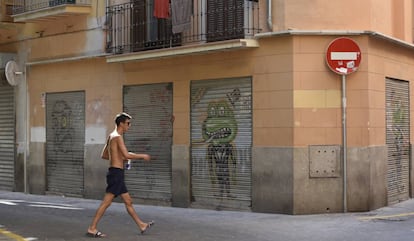 Un turista descamisado pasea por el centro histórico de Palma.
