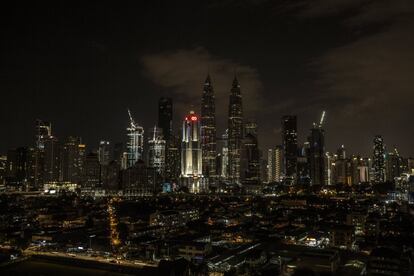 Vista de las Torres Petronas (C) con luz apagada durante la Hora del Planeta en Kuala Lumpur, Malasia, 24 de marzo de 2018.