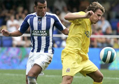 El delantero del Villarreal Diego Forlán disputa el balón con el defensa del Recre Antonio Sánchez de la Calle