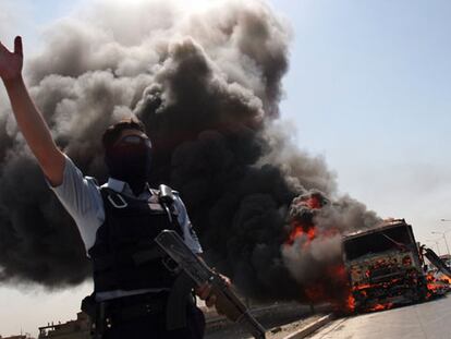 Un policía iraquí, ante un camión ardiendo tras sufrir un atentado en Bagdad.
