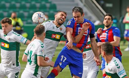 Kike García remata de cabeza ante la oposición de Gonzalo Verdú durante el Elche-Eibar.