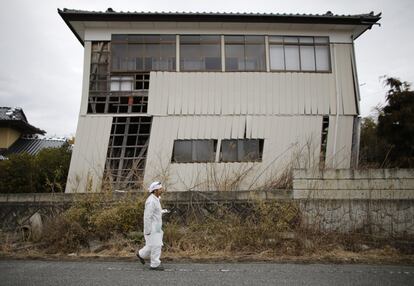 Cuatro años después del terremoto y posterior tsunami que arrasó el noreste de Japón el 11 de marzo de 2011, el país sigue luchando contra las secuelas del seísmo, especialmente por el grave accidente que sufrió la central nuclear de Fukushima. En la imagen, Norio Kimura, que perdió a su padre, su mujer y su hija en el terremoto, camina frente a una casa dañada en una zona de exclusión en el pueblo de Okuma, situado junto a la central nuclear de Fukushima. Kimura se ha negado a vender al Gobierno una parcela donde las autoridades pretenden enterrar los residuos radiactivos.