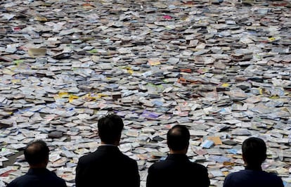 Oficiales del gobierno chino miran miles de dvd y cd piratas que serán destruidos en la ciudad de Taiyuan (China).