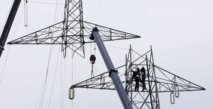 Varios operarios reparan una torre de tendido el&eacute;ctrico.  
 