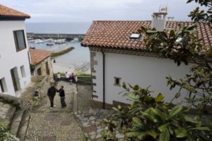 Vista de una de las empinadas calles de Lastres (Asturias), con el puerto al fondo.