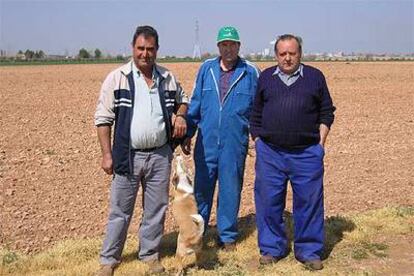 Juan Sánchez, en el centro, delante de la tierra que ha dejado sin sembrar en la provincia de Ciudad Real.