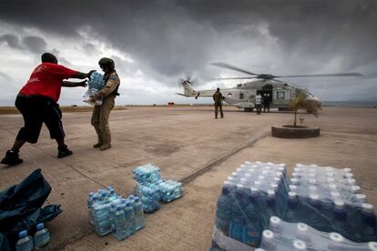 En la imagen, soldados holandeses descargan agua potable desde un helicóptero para ayudar a la población local, en el Aeropuerto Internacional Princesa Juliana, en la parte holandesa de San Martín.