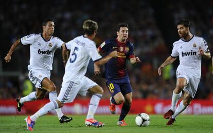 Messi trata de zafarse de Cristiano, Coentrão y Alonso, durante la última Supercopa.