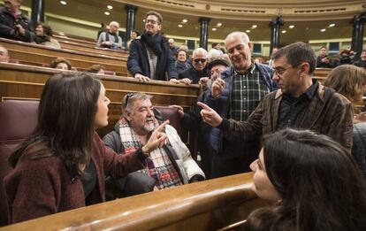 Juan Carlos Monedero e Irene Montero junto a un grupo de ciudadanos sentados en los escaños del grupo parlamentario de Podemos.