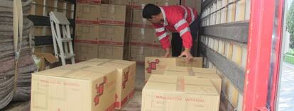 Operarios transportan y cargan las 129 cajas en el cami&oacute;n que las trasladar&aacute; a la Audiencia Nacional. 