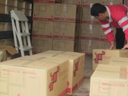 Operarios transportan y cargan las 129 cajas en el cami&oacute;n que las trasladar&aacute; a la Audiencia Nacional. 