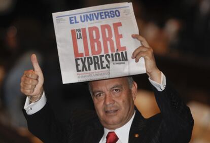 El parlamentario opositor Ramiro Teran muestra un ejemplar del diario 'El Universo' durante el discurso del  presidente Correa en la Asamblea Nacional