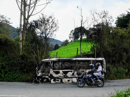 Una moto pasa frente a un autobús quemado por miembros del Clan del Golfo, cerca de Yarumal, Antioquia, el pasado 6 de mayo.