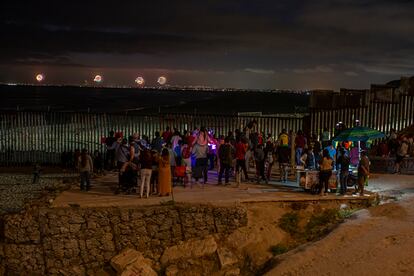 Personas observan los fuegos artificiales del 4 de julio de 2022 desde el otro lado del muro fronterizo, en Tijuana (México).