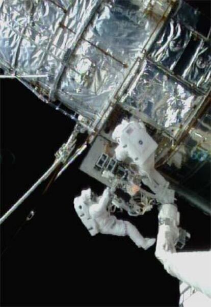 Dos astronautas trabajan en la reparación del telescopio <i>Hubble</i> en 1997.
