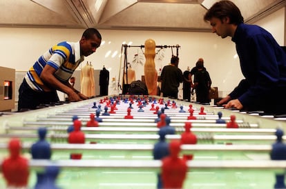 Amantes del arte juegan con el 'Stadium', de Maurizio Cattelan, un futbolín de siete metros de largo para 11 jugadores, en la Tate Gallery en Londres. La obra es parte de 'Abracadabra', una provocativa exposición, con un humor desenfadado.