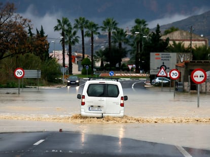 Una furgoneta intenta atravesar una vaguada inundada en una carretera a las afueras de Orihuela (Alicante).