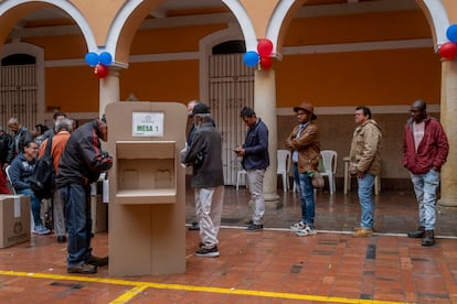 Ciudadanos esperan en fila para emitir su voto en el Colegio Mayor de San Bartolomé, en Bogotá, este domingo.