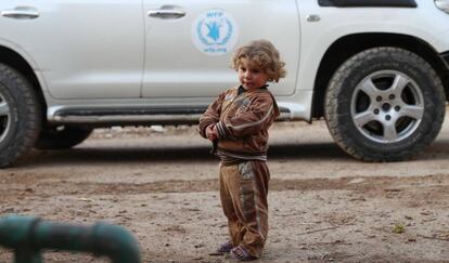 Un ni&ntilde;o se para junto a un veh&iacute;culo del Programa Mundial de Alimentos que forma parte de la operaci&oacute;n humanitaria en la zona de Al-Nishabieh, en una zona rural de Damasco (Siria), el 28 de noviembre de 2017.