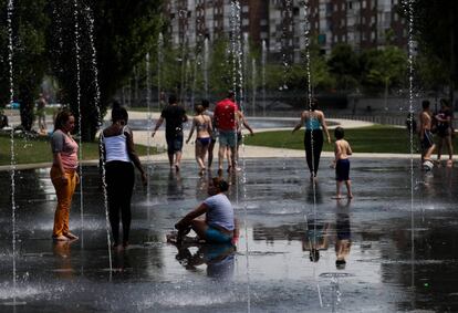 Varias personas se refrescan en el parque Madrid Río el 15 de junio de 2017.