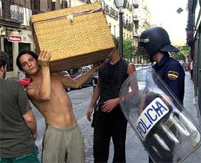 Uno de los cerca de 20 jóvenes desalojados por la policía saca sus pertenencias del edificio ocupado en Madrid.