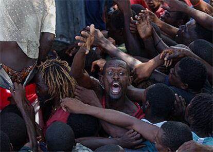 Un hombre grita entre una multitud que intenta alcanzar un camión de alimentos, ayer en Gonaives.