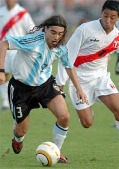 El argentino Juan Pablo Sorin pugna por el balon con el peruano Nolberto Solano.