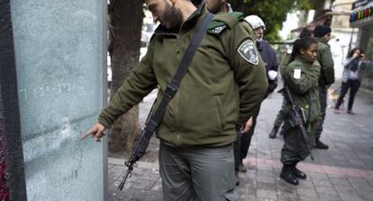 Un polic&iacute;a israel&iacute; apunta al impacto de una de las balas disparadas contra los clientes del bar de Tel Aviv.