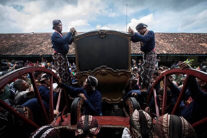 Personal del palacio Kraton de Yogyakarta, que pertenece al sultán de Yogyakarta, lavan un carro tirado por caballos durante un ritual anual en el Museo de Autos en Yogyakarta, Indonesia.