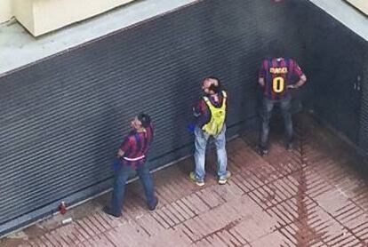 Diverses persones pixen al costat del bar La Jarra, situat en una comunitat de veïns.