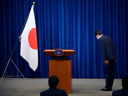 O primeiro-ministro do Japão, Shinzo Abe, se curva diante da bandeira japonesa ao anunciar a decisão de deixar o cargo que ocupa há oito anos, por motivos de saúde.