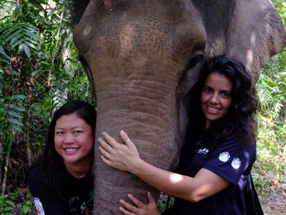Alicia Solana (derecha) y una compa&ntilde;era abrazan a un elefante en Malasia.