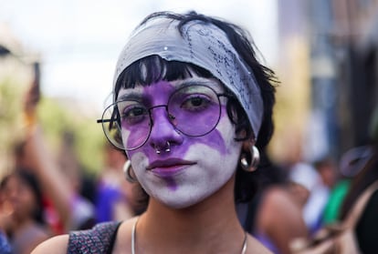 Una mujer con el rostro pintando participa en la marcha. 