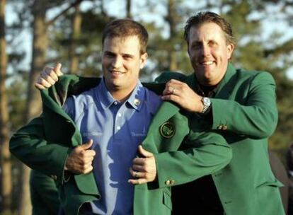 Zach Johnson recibe la chaqueta verde del campeón del año pasado Phil Mickelson.