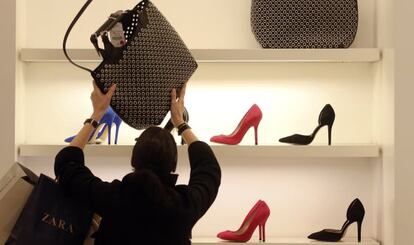 Una mujer mira un bolso en una tienda de Zara