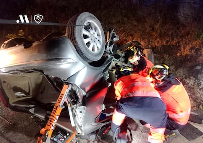 Bomberos trabajan sobre los restos del vehículo accidentado cerca de Ronda (Málaga), en el que han fallecido tres jóvenes este miércoles.