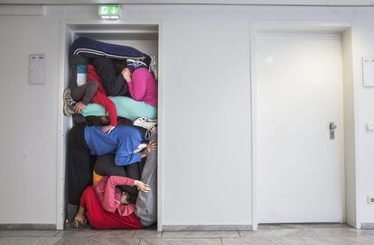 Miembros de un grupo de 'performance' dirigidos por el coreógrafo austriaco Willi Dorner se apilan en el marco de una puerta en la Feria del Libro de Fráncfort (Alemania). Esta actuación forma parte de la nueva campaña cultural que Austria presenta en la feria que se celebra del 14 al 18 de octubre de 2015.