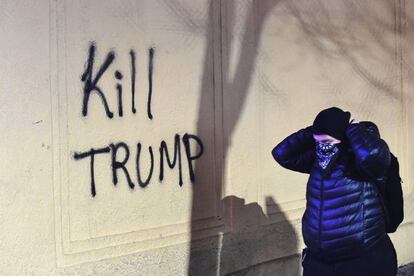 Una mujer camina junto a un grafiti que dice 'Matad a Trump' durante una protesta contra el escritor ultraderechista Milo Yiannopoulos durante una protesta en Berkeley.