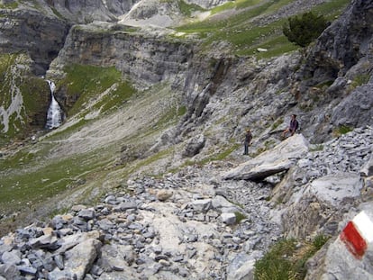 Señal roja y blanca de la ruta GR 11 a su paso por el valle de Ordesa (Huesca). Al fondo, la cascada Cola de Caballo.