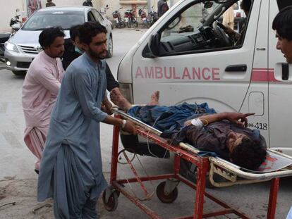 Una víctima del ataque suicida hoy en Pakistán en un mitin es evacuado de la zona de la explosión.