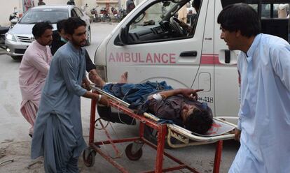 Una víctima del ataque suicida hoy en Pakistán en un mitin es evacuado de la zona de la explosión.