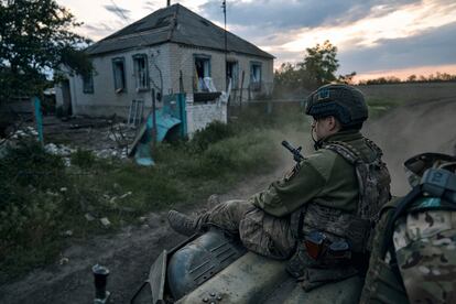 A Ukrainian soldier rides atop an APC on the frontline in the Luhansk region, Ukraine