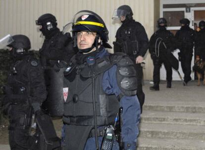 Varios agentes de la policía francesa abandonan un domicilio en el barrio de Villiers-le-Bel tras detener sospechosos de haber participado en los disturbios del pasado noviembre.