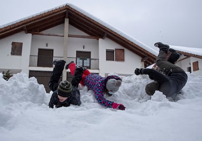 Tres niños se divierten en la nieve caída en Espinal (Navarra).