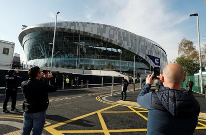 Unos aficionados fotografían la zona acristalada del exterior del nuevo estadio.