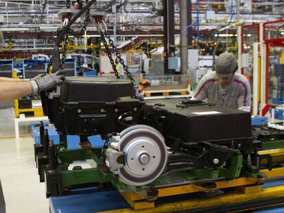 Dos operarios colocan hoy las baterías de la furgoneta eléctrica Citroën Berlingo en la cadena de montaje de la planta de PSA. 