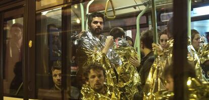 Varias personas cubiertas con mantas térmicas son evacuadas en un autobús en las inmediaciones de la sala Bataclan en París.