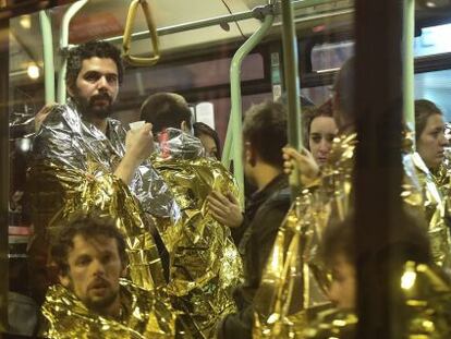 Varias personas cubiertas con mantas térmicas son evacuadas en un autobús en las inmediaciones de la sala Bataclan en París.
