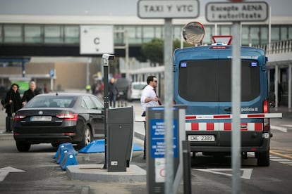 Un conductor de vehiculo VTC habla con agentes de los Mossos en la Terminal 2 del aeropuerto de Barcelona.